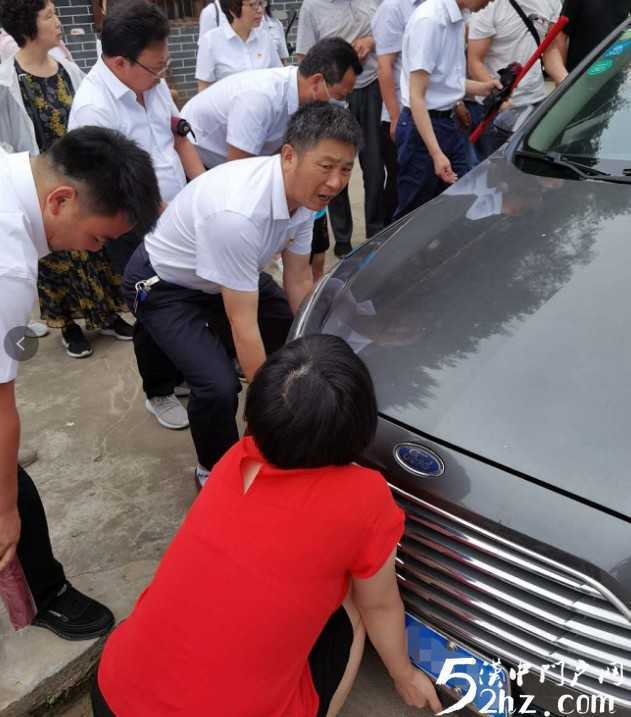 女司機開車掉進溝里，洋縣眾黨員幫忙抬車